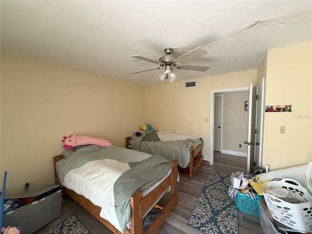 bedroom featuring ceiling fan, visible vents, and wood finished floors