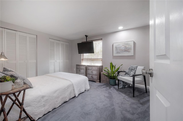 bedroom featuring dark carpet and two closets