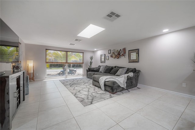 living room featuring light tile patterned floors and a skylight