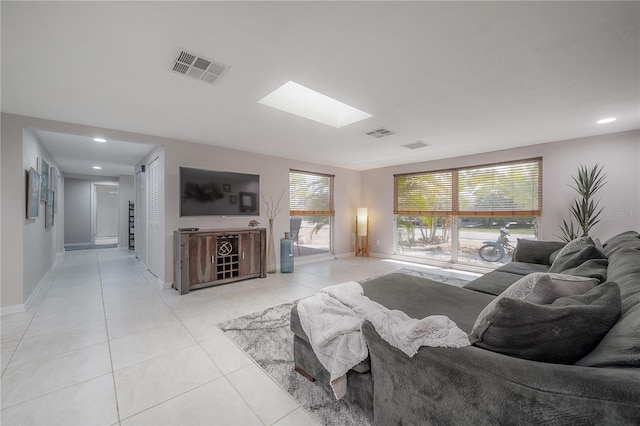 living room with light tile patterned floors and a skylight