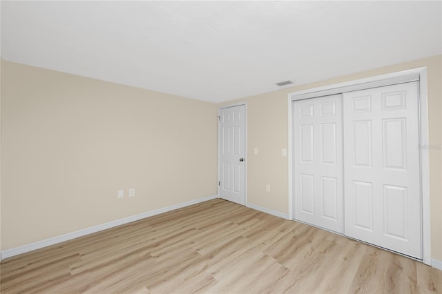 unfurnished bedroom with a closet and light hardwood / wood-style flooring