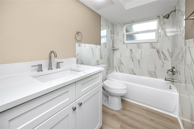 full bathroom featuring tiled shower / bath combo, vanity, hardwood / wood-style flooring, and toilet