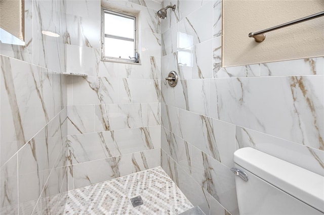 bathroom featuring tiled shower and toilet