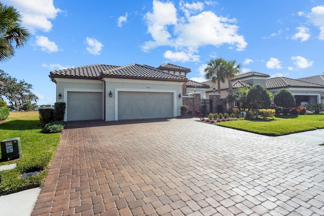 mediterranean / spanish-style house featuring a garage and a front lawn