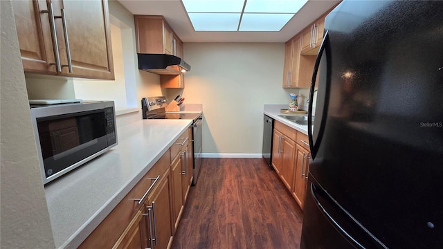 kitchen featuring a skylight, stainless steel appliances, and dark hardwood / wood-style floors