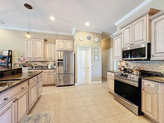 kitchen featuring hanging light fixtures, appliances with stainless steel finishes, light tile patterned floors, and dark stone counters