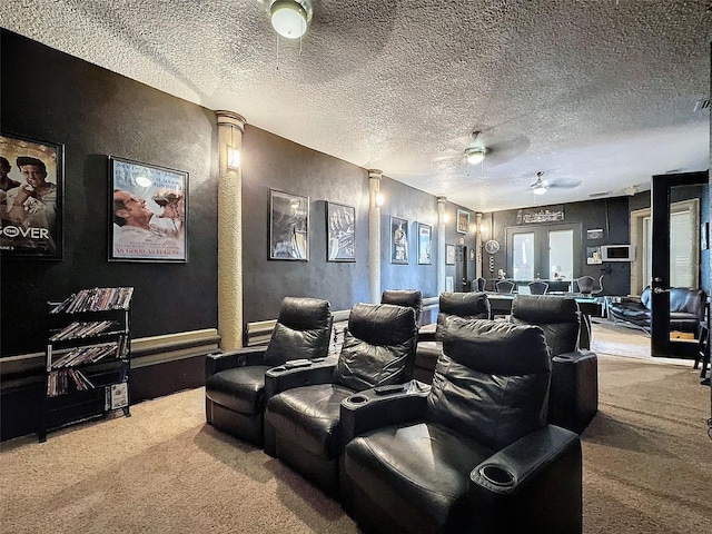 carpeted cinema room with ceiling fan, a textured ceiling, and french doors