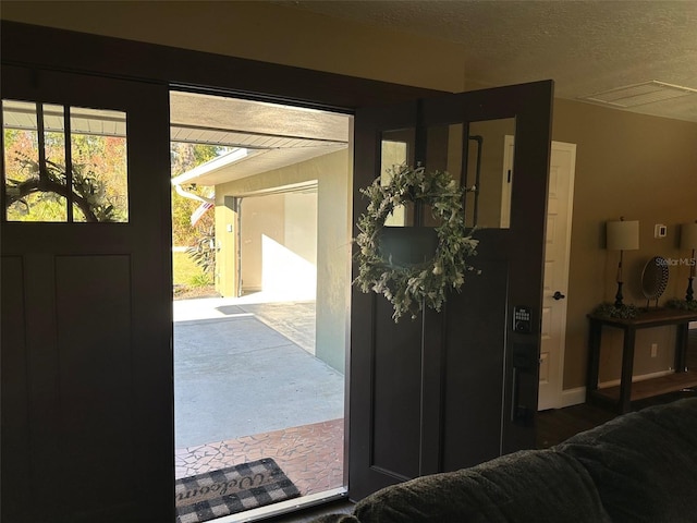 doorway with a textured ceiling and visible vents