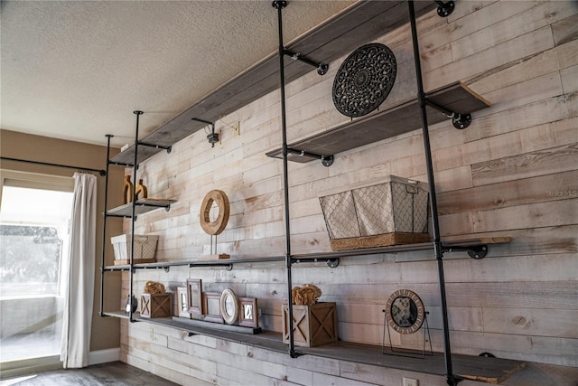 interior space featuring wooden walls and a textured ceiling