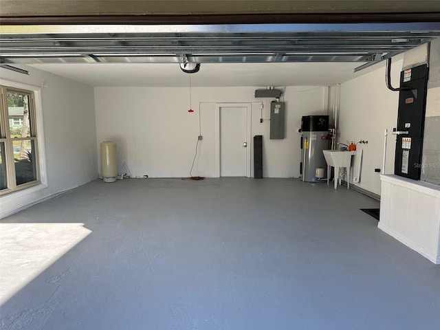 garage featuring water heater, a sink, electric panel, and heating unit