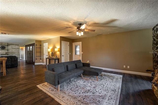 living room with dark wood-style floors, baseboards, and visible vents