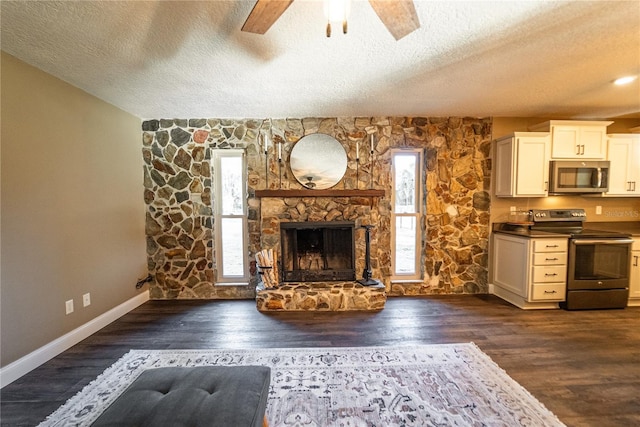 unfurnished living room with dark wood-style floors, a fireplace, a ceiling fan, a textured ceiling, and baseboards