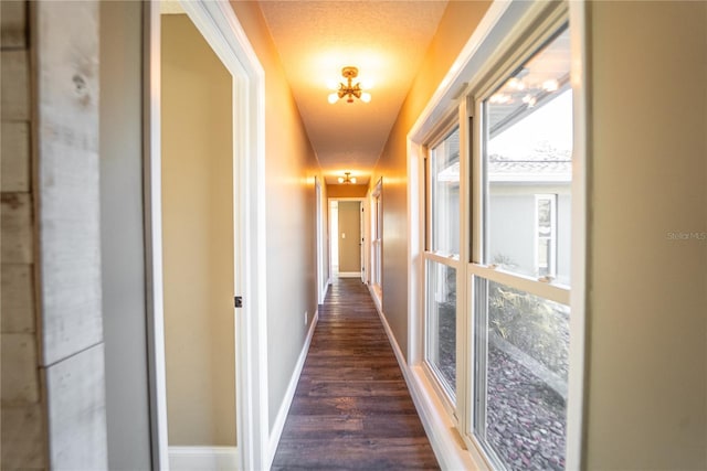 hallway with dark wood-style floors and baseboards