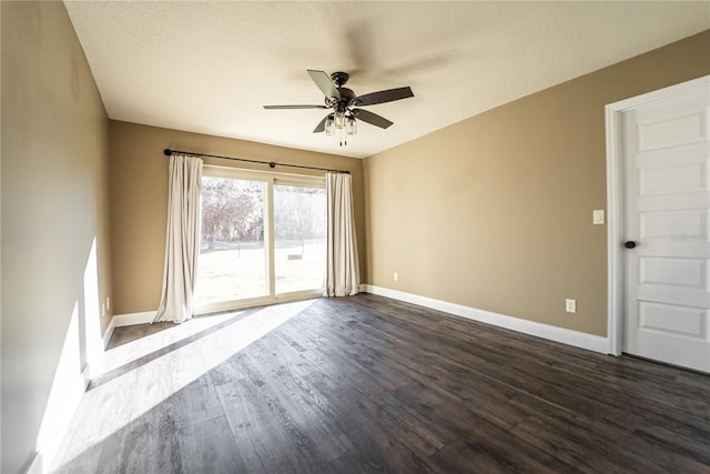 spare room with dark wood-style floors, baseboards, and a ceiling fan