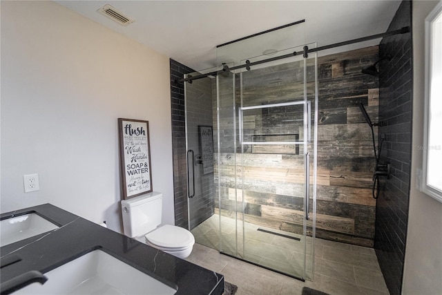 bathroom with tile patterned flooring, toilet, visible vents, vanity, and a stall shower