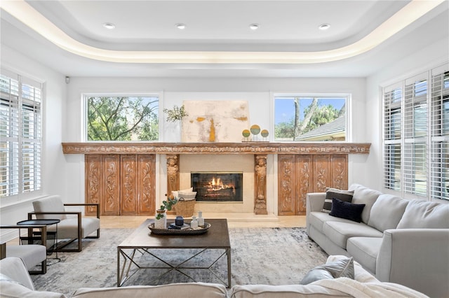 living room with a fireplace and a tray ceiling