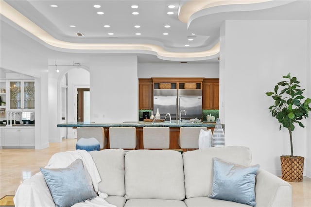 living room featuring a tray ceiling and a high ceiling