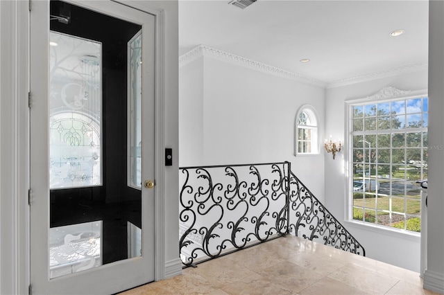 foyer entrance with crown molding, tile patterned floors, and a healthy amount of sunlight