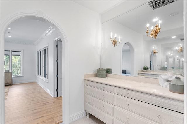 bathroom with an inviting chandelier, vanity, and hardwood / wood-style floors