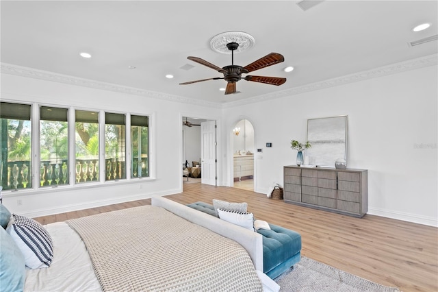 bedroom featuring ceiling fan, ornamental molding, ensuite bathroom, and light hardwood / wood-style floors