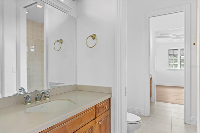 bathroom featuring tile patterned flooring, vanity, walk in shower, and toilet