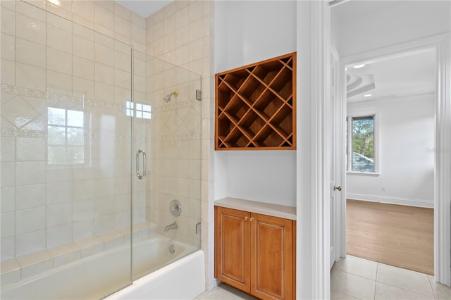 bathroom with bath / shower combo with glass door and tile patterned floors