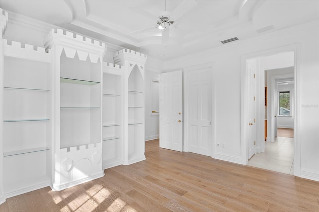 interior space featuring ceiling fan, ornamental molding, a raised ceiling, and light hardwood / wood-style floors