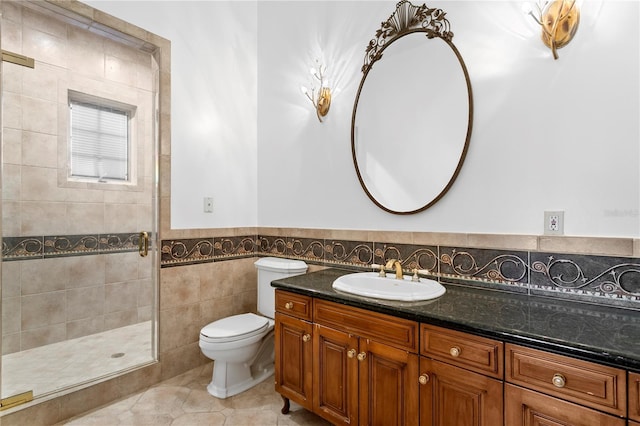 bathroom with tile walls, tile patterned flooring, vanity, a shower with shower door, and toilet