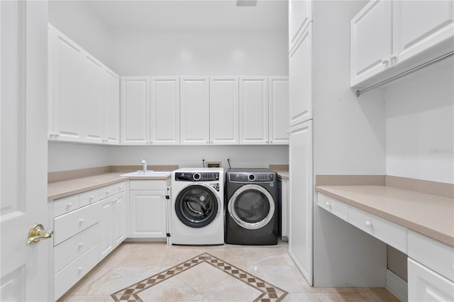 laundry room with cabinets, sink, and washing machine and dryer