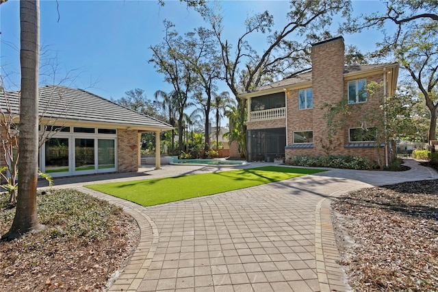 rear view of property featuring a lawn