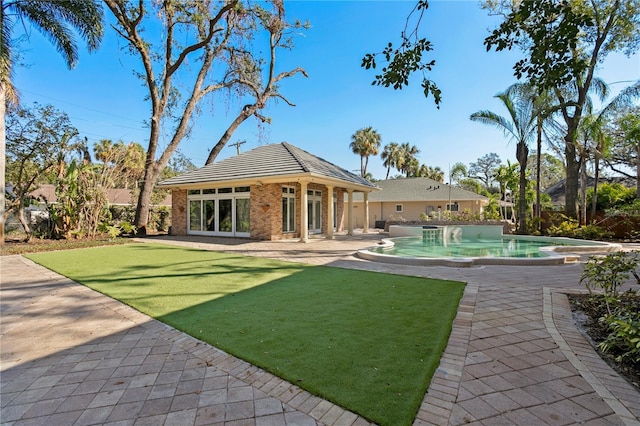 rear view of house with a yard and a patio