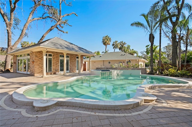 view of pool featuring a hot tub and a patio area