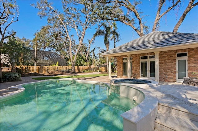 view of pool featuring an in ground hot tub, an outbuilding, and a patio