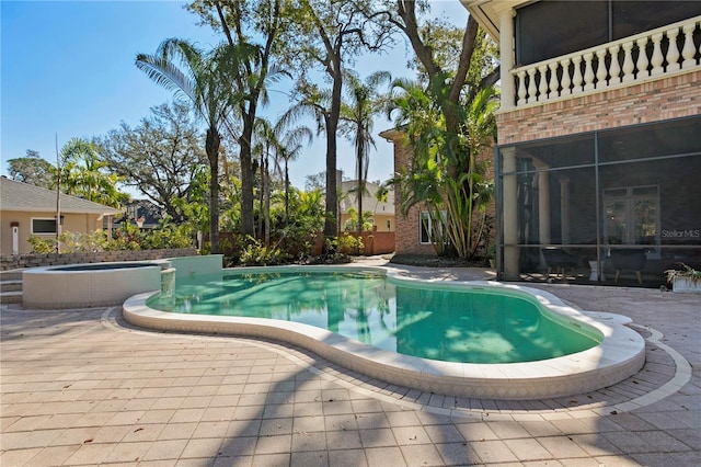 view of swimming pool with a sunroom, a patio, and an in ground hot tub