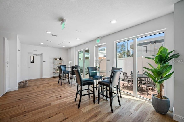 dining space featuring a textured ceiling, wood finished floors, and recessed lighting