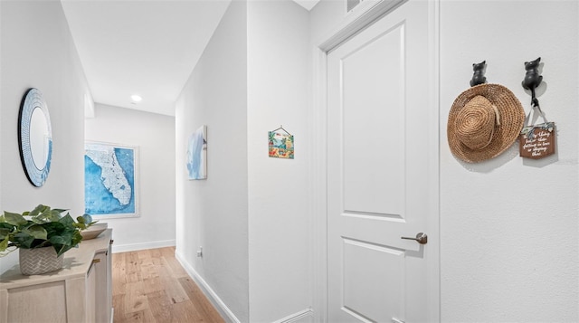 hall featuring light wood-style flooring and baseboards