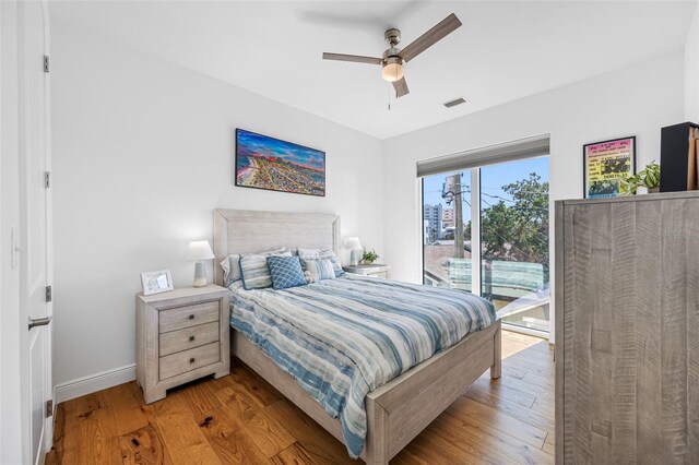 bedroom featuring visible vents, baseboards, ceiling fan, access to outside, and light wood-type flooring