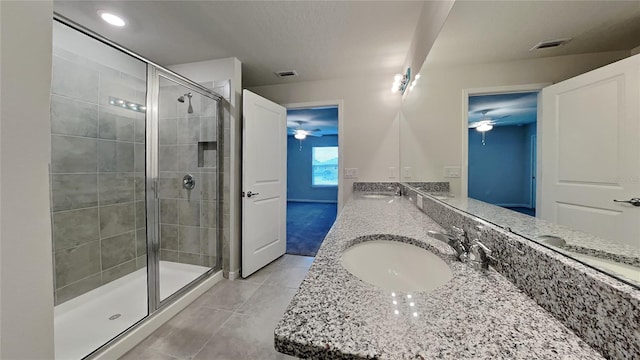 bathroom with tile patterned flooring, vanity, an enclosed shower, and ceiling fan