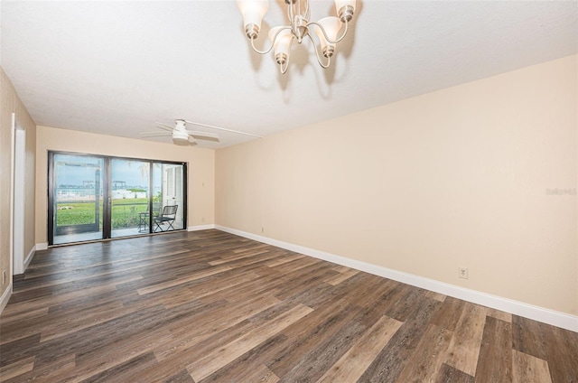 empty room with ceiling fan with notable chandelier and dark hardwood / wood-style floors