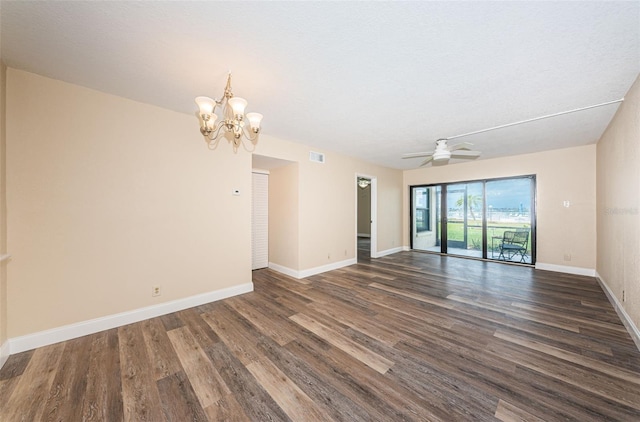 spare room with dark wood-type flooring and ceiling fan with notable chandelier