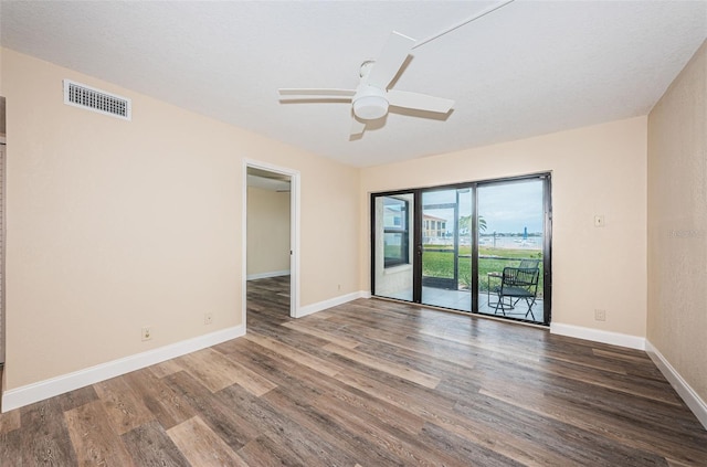 empty room featuring dark wood-type flooring and ceiling fan