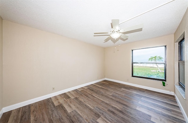 empty room featuring ceiling fan, dark hardwood / wood-style floors, and a textured ceiling