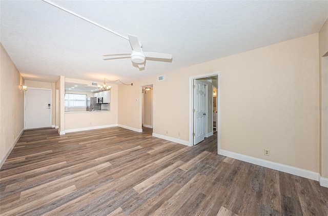 unfurnished living room featuring dark hardwood / wood-style floors, ceiling fan with notable chandelier, and a textured ceiling