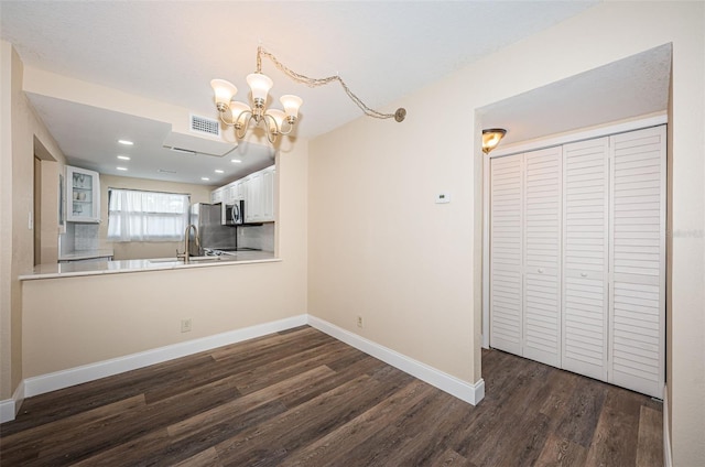 kitchen with backsplash, stainless steel appliances, dark hardwood / wood-style floors, white cabinets, and kitchen peninsula