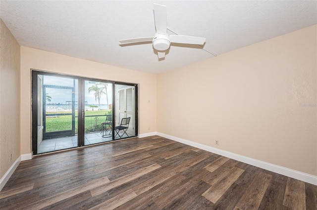 spare room featuring dark wood-type flooring, a textured ceiling, and ceiling fan