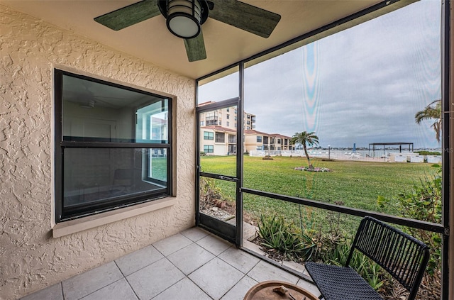 unfurnished sunroom featuring ceiling fan