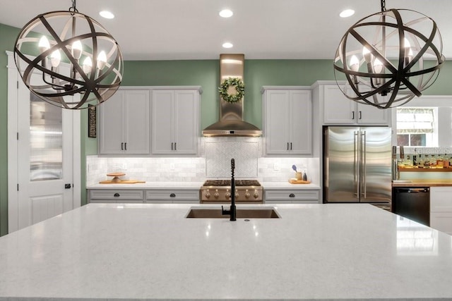 kitchen featuring black dishwasher, white cabinets, a chandelier, stainless steel built in fridge, and wall chimney exhaust hood