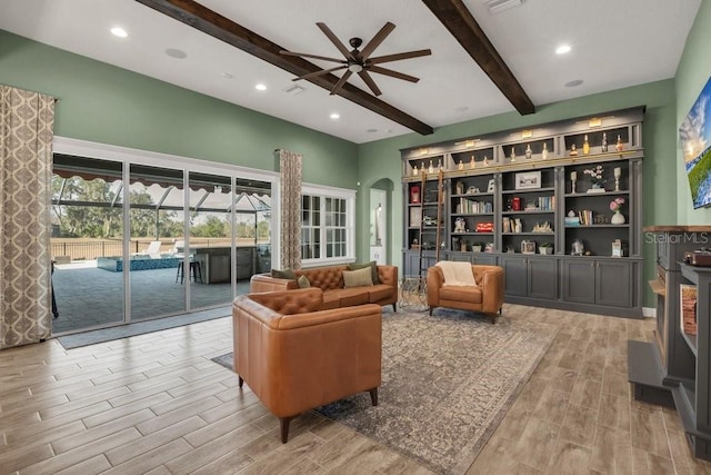 sitting room featuring beamed ceiling and ceiling fan