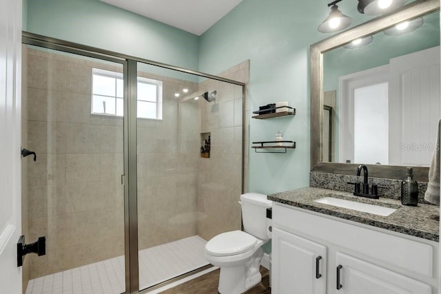 bathroom featuring vanity, toilet, and walk in shower