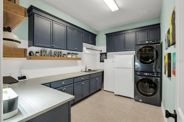 laundry area with stacked washer and dryer, light tile patterned floors, cabinet space, and a sink